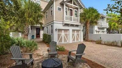 a house with two chairs in front of it at Ocean Park in Santa Rosa Beach