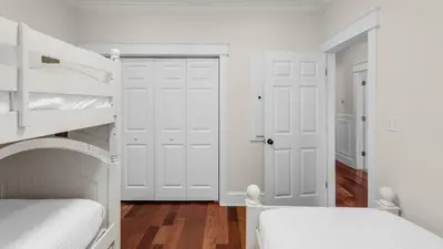 a bedroom with two bunk beds and white doors at License To Chill in Inlet Beach