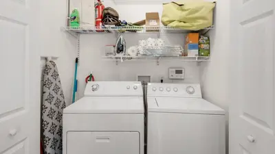 a laundry room with two white washes and shelves at License To Chill in Inlet Beach
