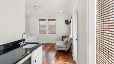 a white kitchen with a sink and a chair at License To Chill in Inlet Beach