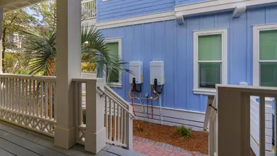 a blue house with a front porch at License To Chill in Inlet Beach