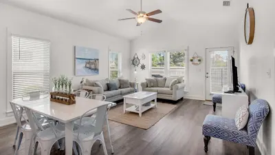 a living room with a white table and chairs at Seabreeze in Panama City Beach