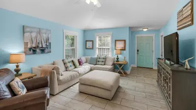a living room with a couch and a flat screen tv at Sandy Teauxs in Panama City Beach