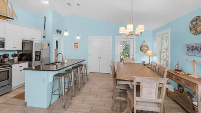 a kitchen with a large wooden table and chairs at Sandy Teauxs in Panama City Beach