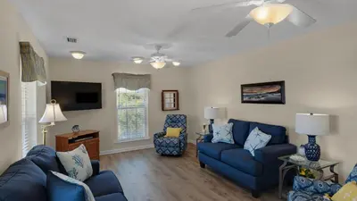 a living room with blue couches and a tv at Beach Daze in Panama City Beach