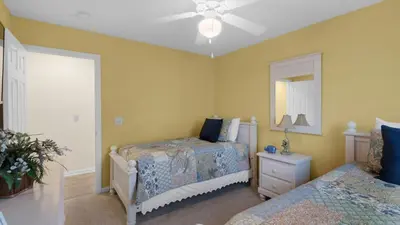 a bedroom with two beds and a mirror at Beach Daze in Panama City Beach