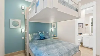 a bedroom with blue walls and a bunk bed at Seasational in Panama City Beach