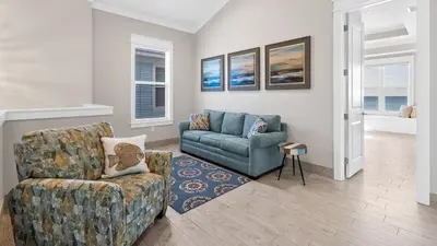 a living room with a couch and a chair at Seasational in Panama City Beach