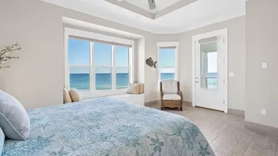 a bedroom with a bed and a view of the ocean at Seasational in Panama City Beach