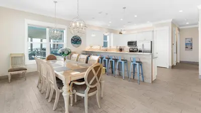 a dining room and kitchen with a table and chairs at Seasational in Panama City Beach