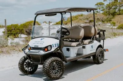 a golf cart parked on the side of a road at Seasational in Panama City Beach