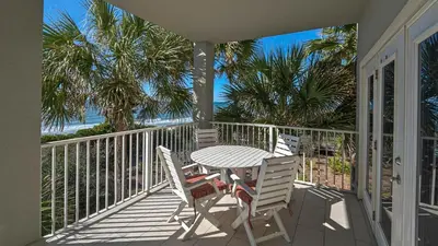 a patio with a table and chairs on a balcony at Seagrove By The Sea IIC in Santa Rosa Beach