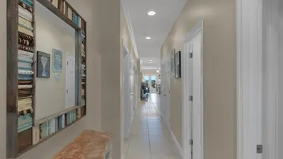 a hallway with white walls and white floors and a long hallway at Seagrove By The Sea IIC in Santa Rosa Beach