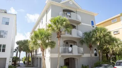 a white building with palm trees in front of it at Seagrove By The Sea IIC in Santa Rosa Beach