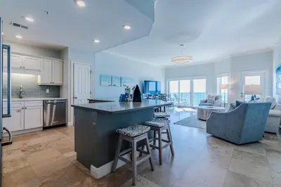 a kitchen and living room with a counter and chairs at Legacy 402-Flemingo's Paradise in Seagrove Beach