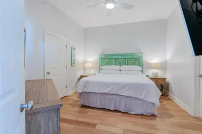 a bedroom with a large bed with a green headboard at Legacy 402-Flemingo's Paradise in Seagrove Beach