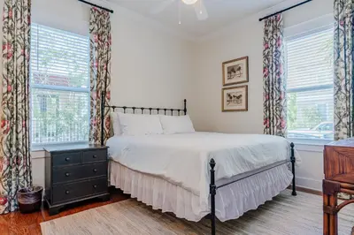 a bedroom with a bed and two windows at Shore Thing in Rosemary Beach