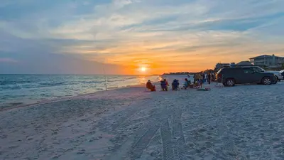 a group of people on a beach at sunset at Beachwood Villas 10H - Bliss at Beachwood in Santa Rosa Beach