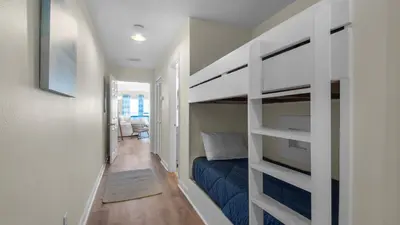 a bedroom with a bunk bed and a hallway at Eastern Shores 106 in Santa Rosa Beach
