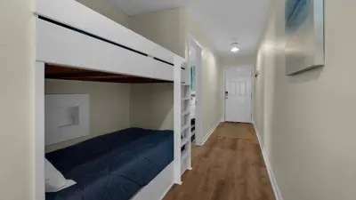 a bedroom with a bunk bed and a hallway at Eastern Shores 106 in Santa Rosa Beach