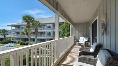 a porch with two chairs and a building at Beachwood Villas 11E - SE Seagrove in Santa Rosa Beach