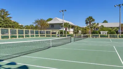 a tennis court with a net in front of a house at Beachwood Villas 11E - SE Seagrove in Santa Rosa Beach