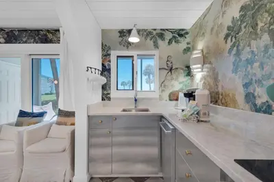 a kitchen with a sink and a living room at Sand Cliffs 107 in Seacrest