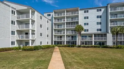 an apartment building with a lawn in front of it at Sand Cliffs 107 in Seacrest