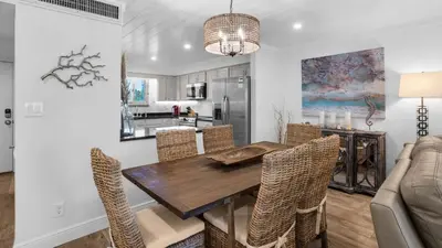 a kitchen and dining room with a wooden table and chairs at Sand Cliffs 106 in Seacrest