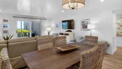 a living room with a wooden table and chairs at Sand Cliffs 106 in Seacrest