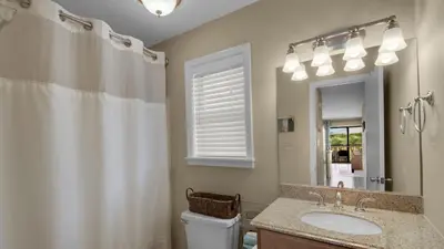 a bathroom with a sink and a toilet and a mirror at Beachwood Villas 10C - A Wave From It All in Santa Rosa Beach