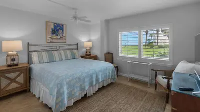 a bedroom with a bed and a desk and two windows at Sand Cliffs 117 in Seacrest