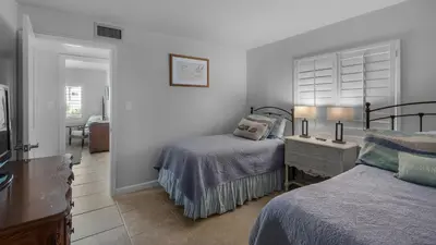 a bedroom with two beds and a table with two lamps at Sand Cliffs 117 in Seacrest