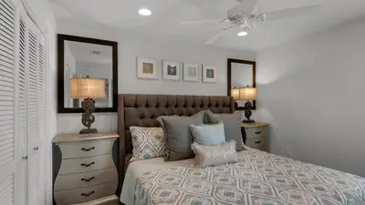 a bedroom with a bed with pillows and a mirror at Beachwood Villas 1D in Santa Rosa Beach