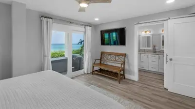 a bedroom with a bed and a view of the ocean at Sand Cliffs 118 in Seacrest