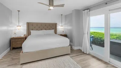 a bedroom with a bed and a view of the ocean at Sand Cliffs 118 in Seacrest