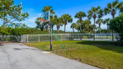 a basketball hoop in a park with palm trees at Sand Cliffs 118 in Seacrest