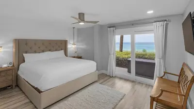 a bedroom with a bed and a view of the ocean at Sand Cliffs 118 in Seacrest