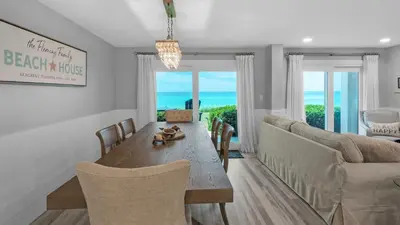 a dining room with a table and a couch at Sand Cliffs 118 in Seacrest