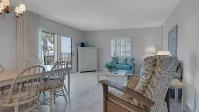 a dining room and living room with a table and chairs at Sand Cliffs 214 in Seacrest
