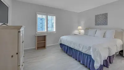 a white bedroom with a bed and a window at Sand Cliffs 214 in Seacrest