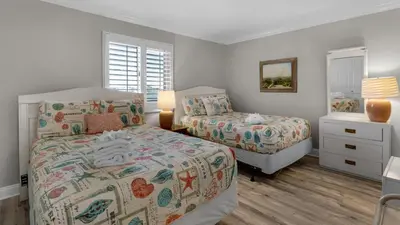 a bedroom with two beds and a window at Sand Cliffs 405 - Sunsets on the Bluff at Sand Cliffs in Seacrest