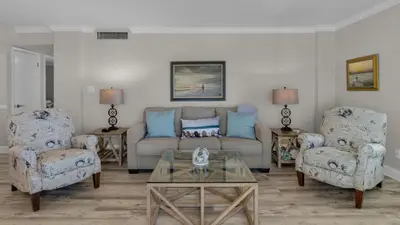 a living room with a couch and two chairs at Sand Cliffs 405 - Sunsets on the Bluff at Sand Cliffs in Seacrest
