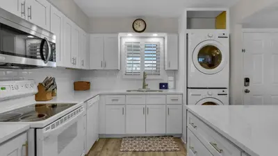 a white kitchen with a sink and a dishwasher at Sand Cliffs 405 - Sunsets on the Bluff at Sand Cliffs in Seacrest