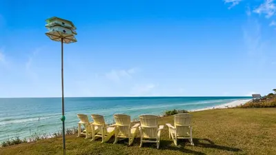 a group of chairs and a table on the beach at Sand Cliffs 415 in Seacrest