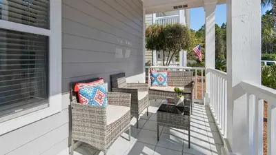 a porch with wicker chairs and a fireplace at A Slice of Lime in Santa Rosa Beach