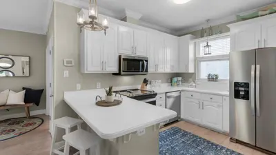 a kitchen with white cabinets and a white counter top at A Slice of Lime in Santa Rosa Beach