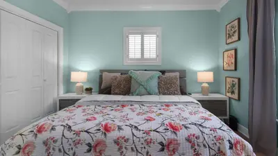a bedroom with a bed with a floral bedspread and two lamps at A Slice of Lime in Santa Rosa Beach