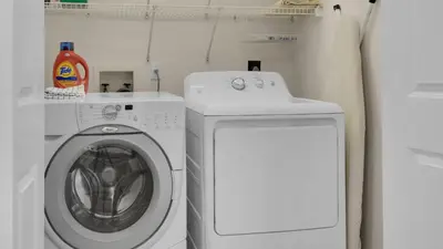 a laundry room with a washing machine and a washer at A Slice of Lime in Santa Rosa Beach