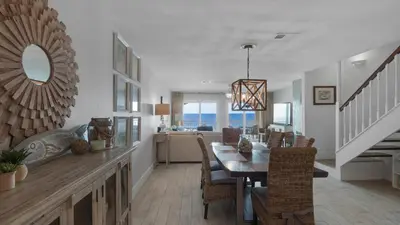 a dining room and living room with a table and chairs at Dune Villas 5B - Sand In My Shoes in Santa Rosa Beach